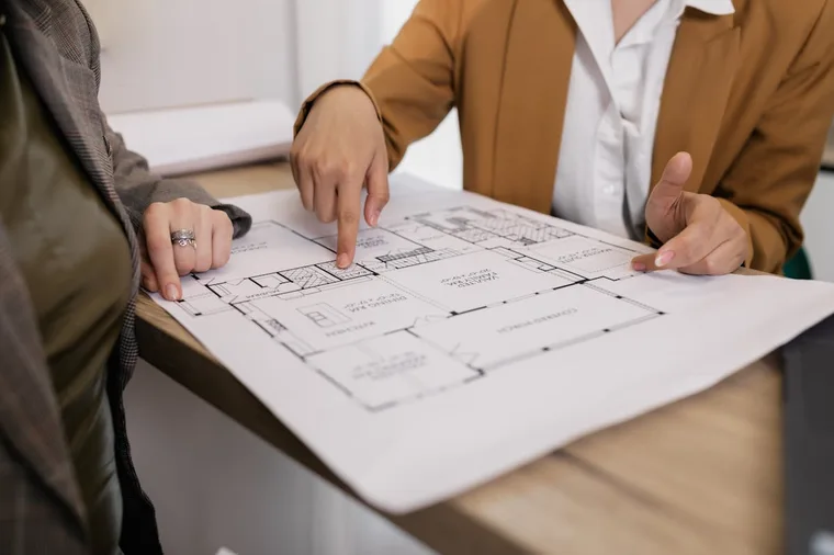 Two professionals reviewing architectural blueprints together