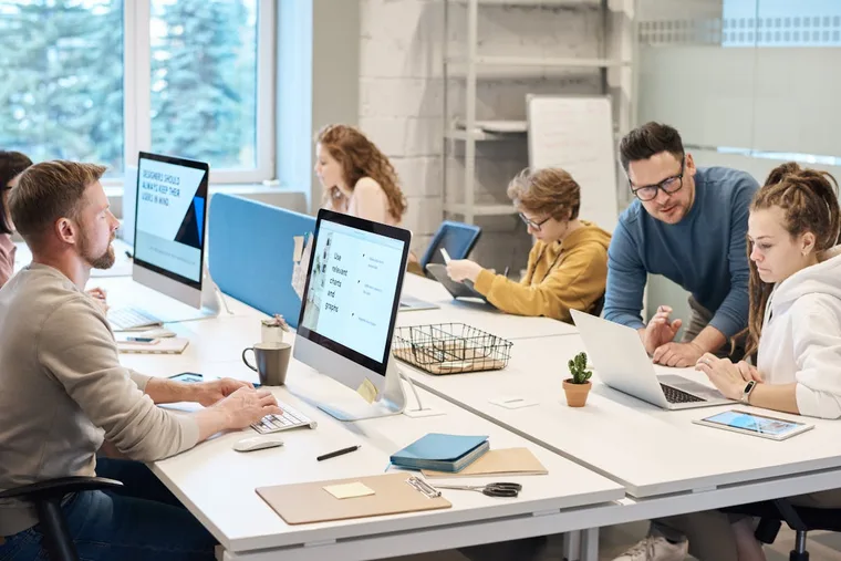 Team of professionals working on laptops at a table